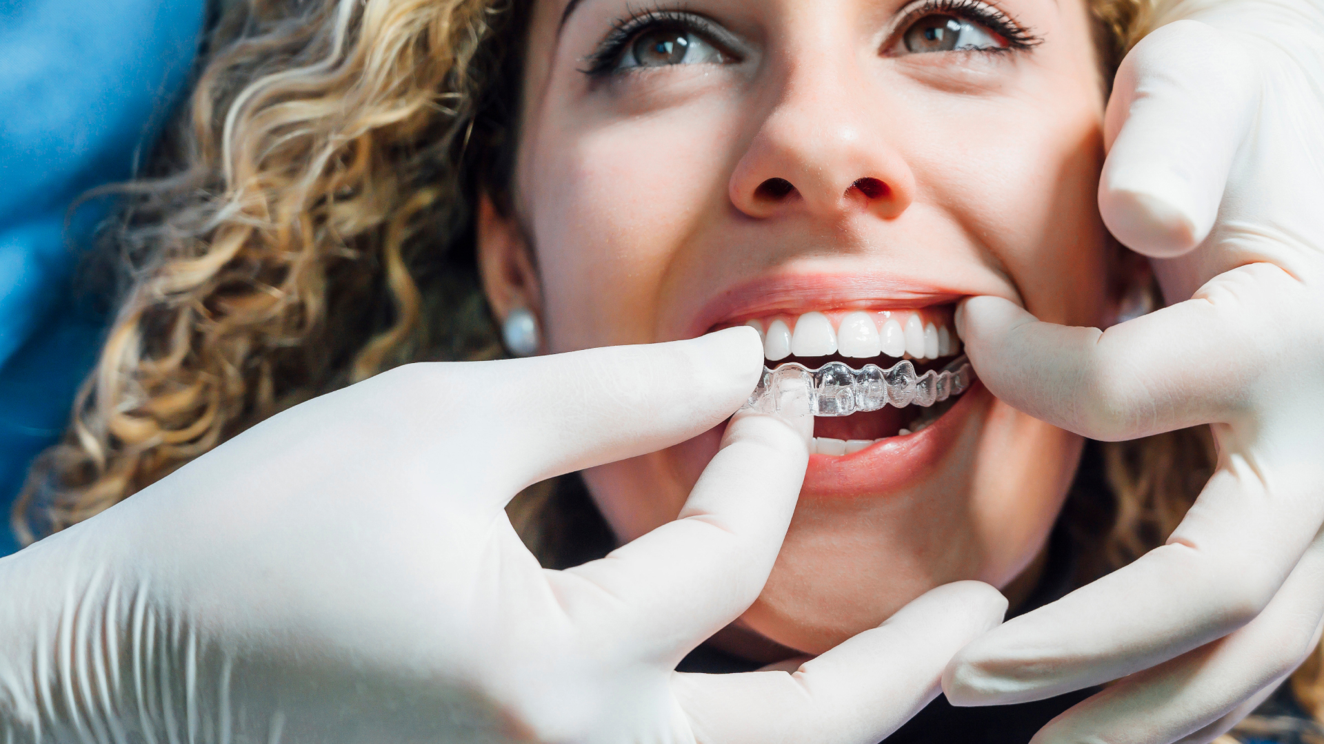 A dentist placing an Invisalign on a patient
