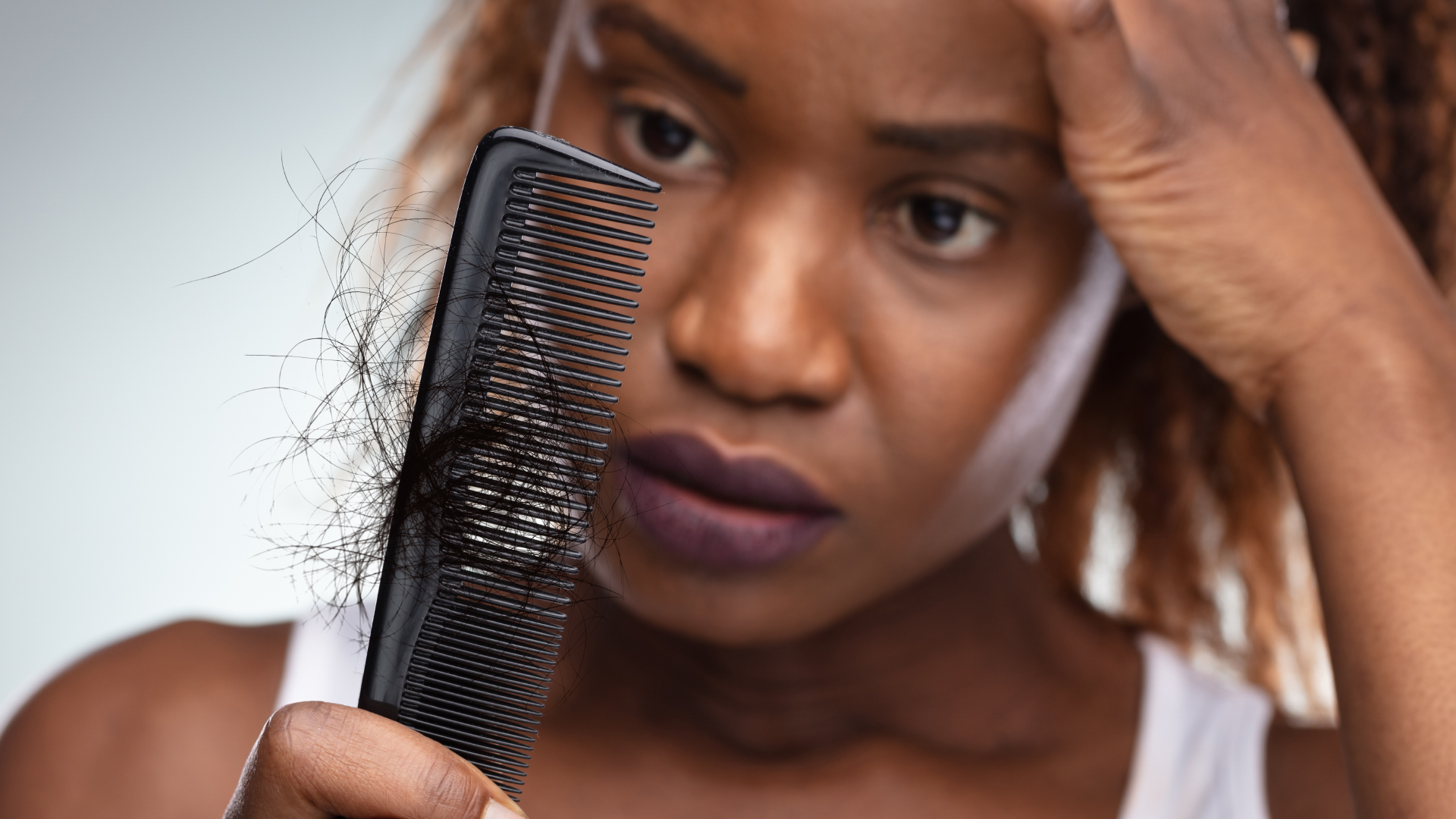 a women with afro hair loosing her hairs