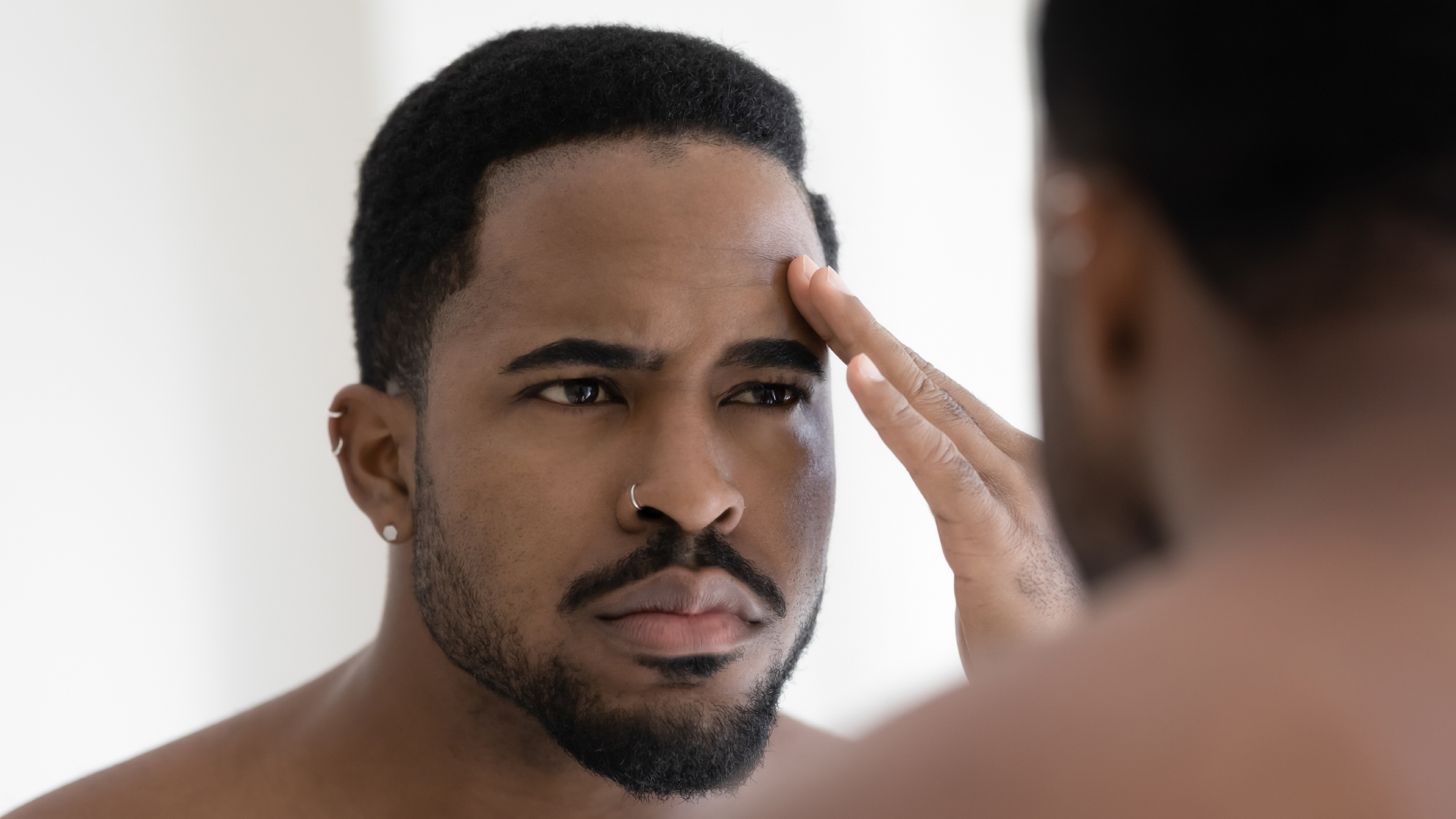 une personne ayant des cheveux afro examine son cuir chevelu