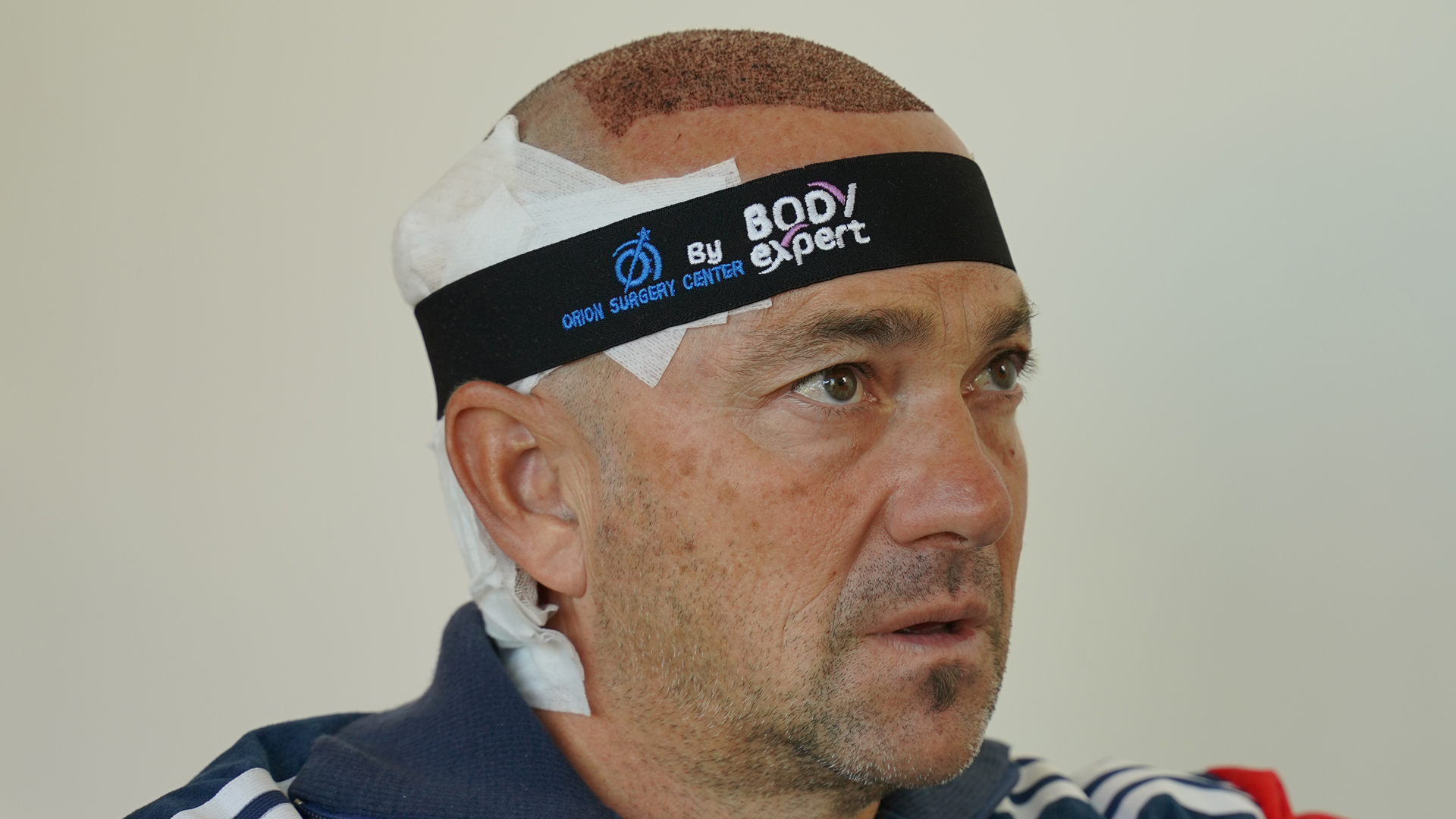 Homme portant un bandeau noir Body Expert et un pansement sur le crâne