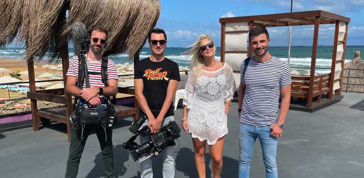 Marie surrounded by the RTL TVI film crew, camera and boom in hand, on a beach