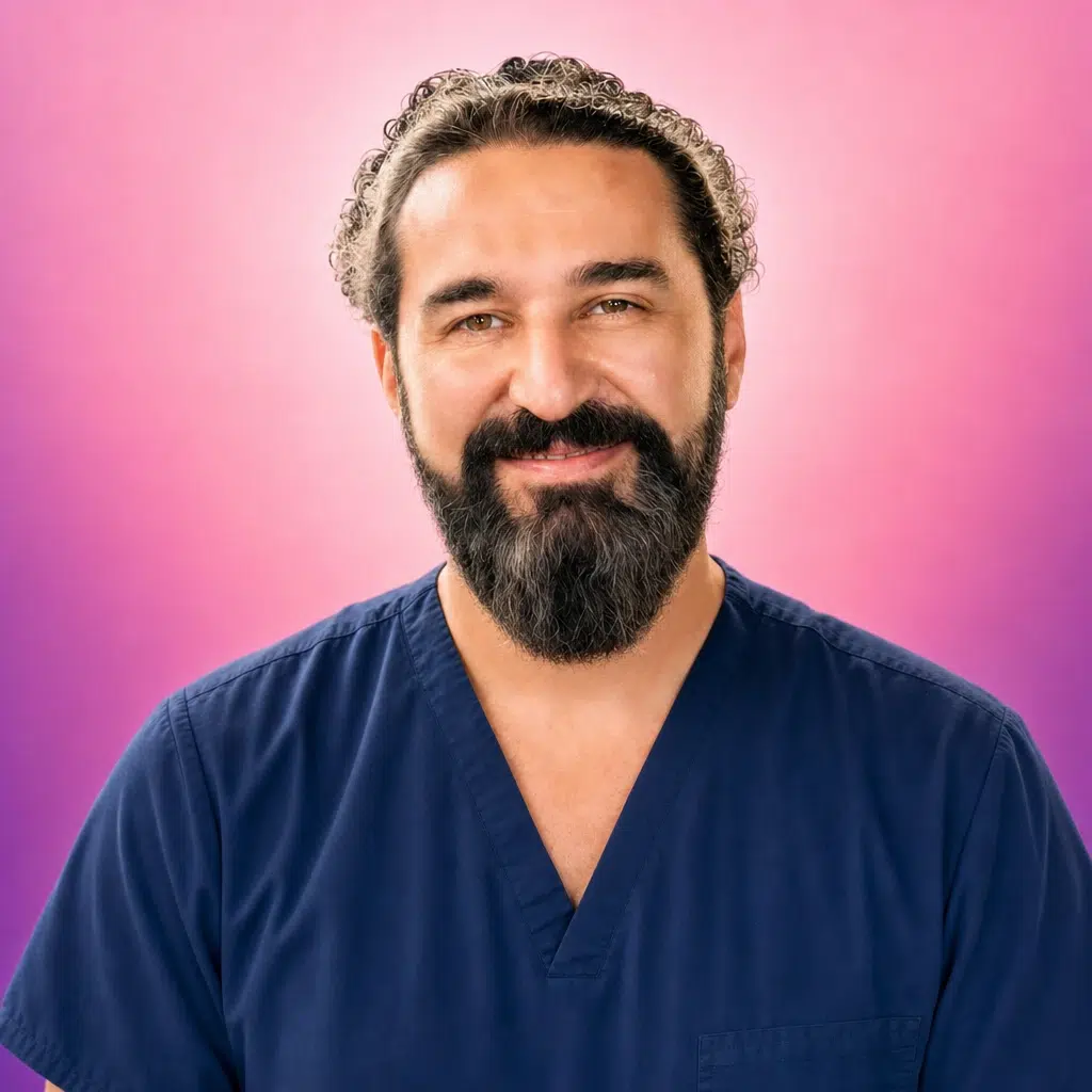 Dr Rüştü Dalgalı de face avec une expression souriante et détendue, sur fond rose clair